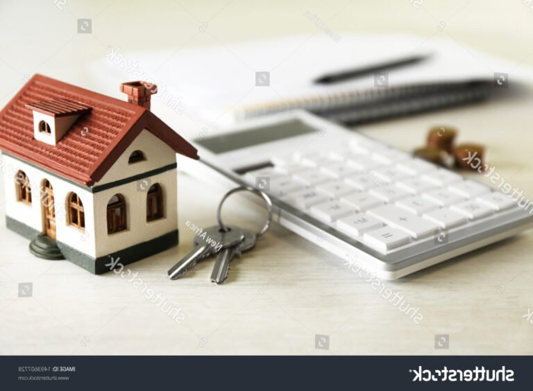 calculatrice et maison miniature sur table lumineuse