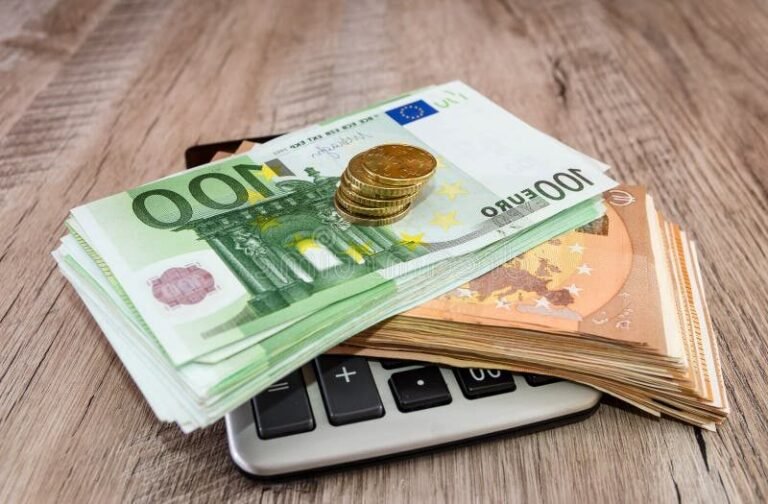 calculatrice et pieces deuros empilees lumineuses