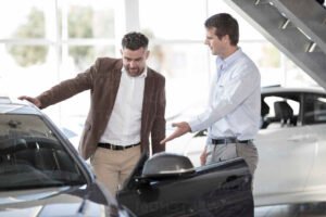 client discutant avec vendeur concessionnaire voiture