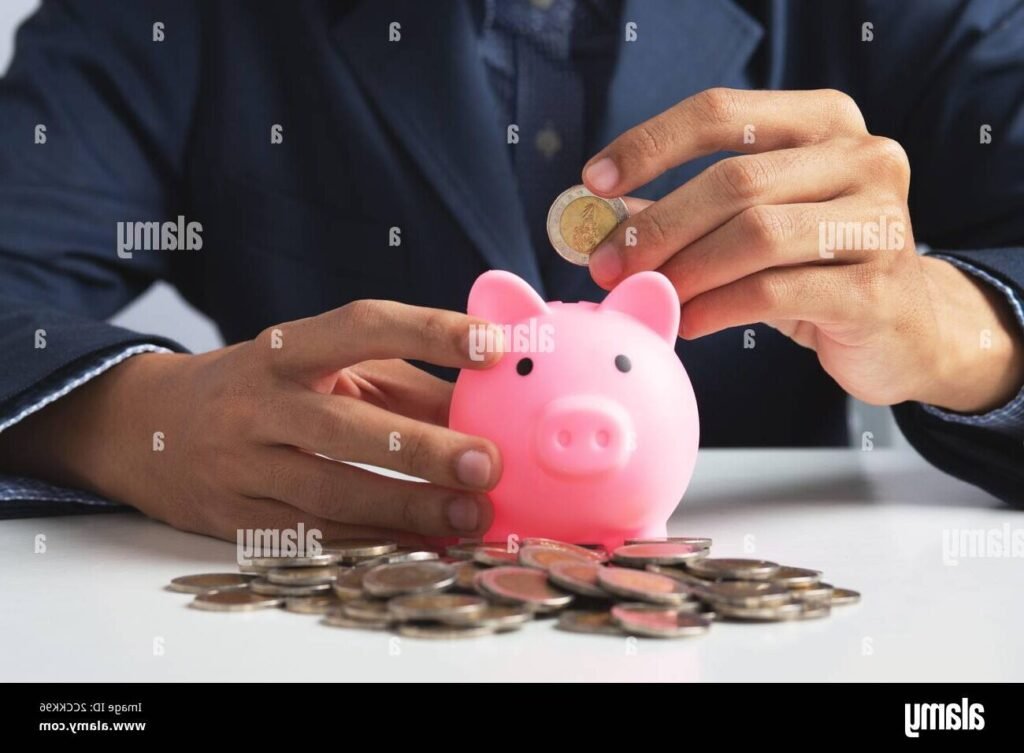 Comment Fonctionne Le Plan Épargne En Actions Au Crédit Agricole 1 main tenant un piggy bank et actions