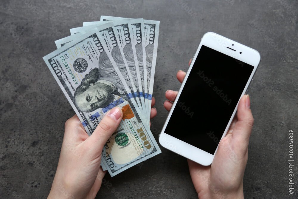 main tenant un smartphone avec billets espece