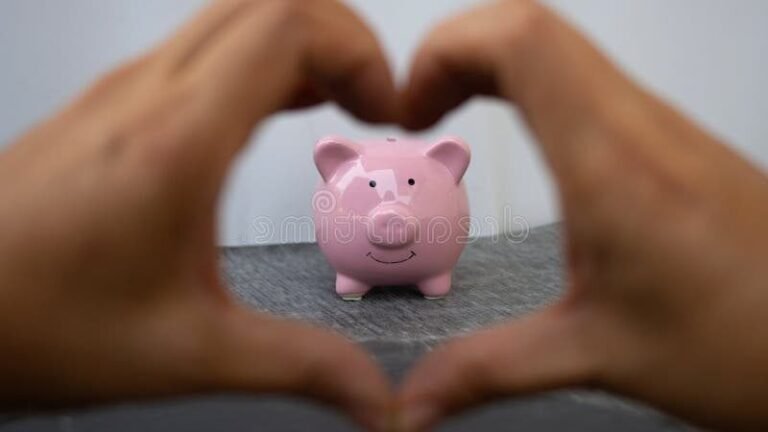 main tenant une tirelire en forme de coeur