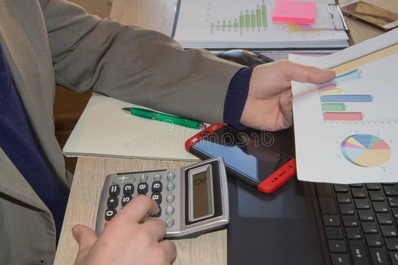 personne reflechissant avec des calculatrices et documents financiers