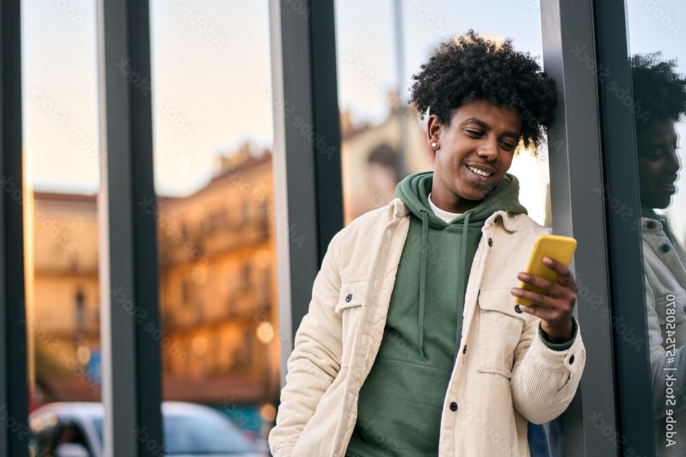 personne souriante consultant son smartphone dehors