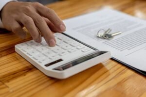 personne utilisant une calculatrice et contrat immobilier